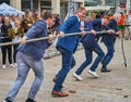 Young men and middle-aged men pull together on a rope during the fun championship in bus pulling Royalty Free Stock Photo
