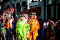 Young men in motley costumes pass on city street at dominican annual carnival