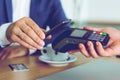 Man paying bill through smartphone using NFC technology in cafe Royalty Free Stock Photo