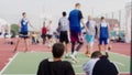 Young men play basketball on sports ground