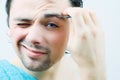 Young men pluck his eyebrows. Royalty Free Stock Photo