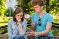 A young man points a finger at a smartphone girl. The problem is in the relationship. Emotions of mistrust. Concepts of Royalty Free Stock Photo