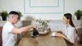 Man pours tasty tea into woman cup in cozy modern cafe