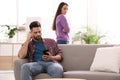 Young man preferring smartphone over his girlfriend