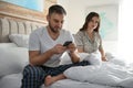 Young man preferring smartphone over spending time with his girlfriend. Jealousy in relationship