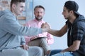 Young men reconciled during therapy with counselor for rebellious teenagers