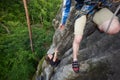 Young man helping girl climbing rocky mountain top. Tourism, traveling and healthy lifestyle concept