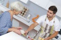 Young man serving meal to elderly lady Royalty Free Stock Photo