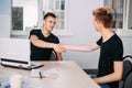 Young men shaking hands hiring new team member