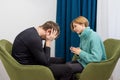 A young man sits in a chair and talks to a psychologist. Healthcare concept of professional psychologist doctor consulting in Royalty Free Stock Photo