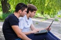 Young men sitting on the ground using laptop Royalty Free Stock Photo