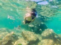 Young men snorkeling exploring underwater coral reef landscape background in the deep blue ocean with colorful fish and Royalty Free Stock Photo