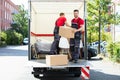 Young Men Stacking The Cardboard Boxes In Moving Truck Royalty Free Stock Photo