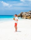 Young men in swim short with a coconut drink on a tropical beach La Digue Seychelles Islands Royalty Free Stock Photo