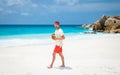 Young men in swim short with a coconut drink on a tropical beach La Digue Seychelles Islands Royalty Free Stock Photo