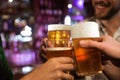 Young men toasting with beer while sitting in pub together Royalty Free Stock Photo