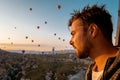 Young men on vacation Cappadocia Turkey sunrise in the hills with hot air balloons, Kapadokya Beautiful vibrant colorful Royalty Free Stock Photo