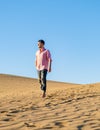 Young men walking at the beach of Maspalomas Gran Canaria Spain, men at the sand dunes desert Royalty Free Stock Photo