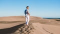 Young men walking at the beach of Maspalomas Gran Canaria Spain, men at the sand dunes desert