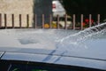 Young men washing silver car with pressured water and brush at sunny day. Close up of cleaning car on summer time Royalty Free Stock Photo