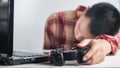 Young Men wear red Scott pattern shirt sleeping Hand holding Joystick gamepad and laptop Royalty Free Stock Photo