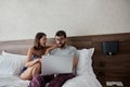 Man and woman in the bed with laptop and surfing on internet. Modern lifestyle concept