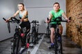 Young man and woman biking in the gym, exercising legs doing cardio workout cycling bikes. Royalty Free Stock Photo