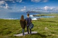 Young man and woman thoughtfully look at the sea landscape of Coumeenoole beach at the Atlantic coast of Ireland Royalty Free Stock Photo