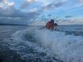 Young man and woman drifting across the sea surface. People on Jet Ski have fun in Ocean. Driver in action during splashing water.