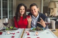 Young couple having romantic dinner in the restaurant sitting together taking photos grimase Royalty Free Stock Photo