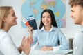 Young couple in a tour agency communication with a travel agent travelling concept holding documents