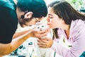 Young men and women playing and kissing their white cat Royalty Free Stock Photo