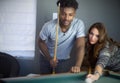 Young men and women in poolroom playing pool team players portrait billiards table nightlife activity Royalty Free Stock Photo