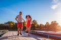 Young man and woman running along summer river dock. Couple having fun at sunset. Guys relaxing Royalty Free Stock Photo