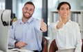 100 customer satisfaction guaranteed. a young man and woman showing thumbs up while working in a call centre. Royalty Free Stock Photo