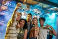 Young men and women smiling while taking selfie using smartphone. Multiracial group of friends hanging out at party in Royalty Free Stock Photo