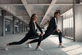 Young man and woman are doing warming up exercises at parking