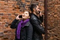 Young man and woman stand nearby back to back, talking on their cell phones Royalty Free Stock Photo