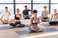 Young men and women in yoga studio practicing alternate nostril breathing exercises Royalty Free Stock Photo