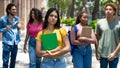 Young mexican female student with group of latin american and caucasian and african young adults Royalty Free Stock Photo