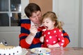 Young middle-aged father feeding cute little toddler girl daughter. Adorable baby child learning eating from spoon Royalty Free Stock Photo