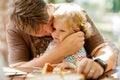 Young middle-aged father feeding cute little toddler girl in restaurant. Adorable baby child learning eating from spoon Royalty Free Stock Photo