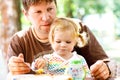 Young middle-aged father feeding cute little toddler girl in restaurant. Adorable baby child learning eating from spoon Royalty Free Stock Photo