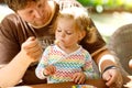 Young middle-aged father feeding cute little toddler girl in restaurant. Adorable baby child learning eating from spoon Royalty Free Stock Photo