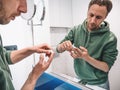 Young middle-aged man uses nourishing and regenerating cream for problem areas on his face. Skincare, wellbeing and Royalty Free Stock Photo