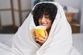 Young middle east woman drinking cup of coffee sitting on bed at bedroom Royalty Free Stock Photo