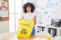 Young middle east woman holding recycling bag with plastic bottles at the office puffing cheeks with funny face Royalty Free Stock Photo