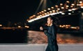 Young middle east woman jogging at night looking in fitness tracker on her wrist