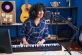 Young middle east woman musician singing song playing piano keyboard at music studio Royalty Free Stock Photo