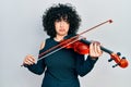 Young middle east woman playing violin depressed and worry for distress, crying angry and afraid Royalty Free Stock Photo